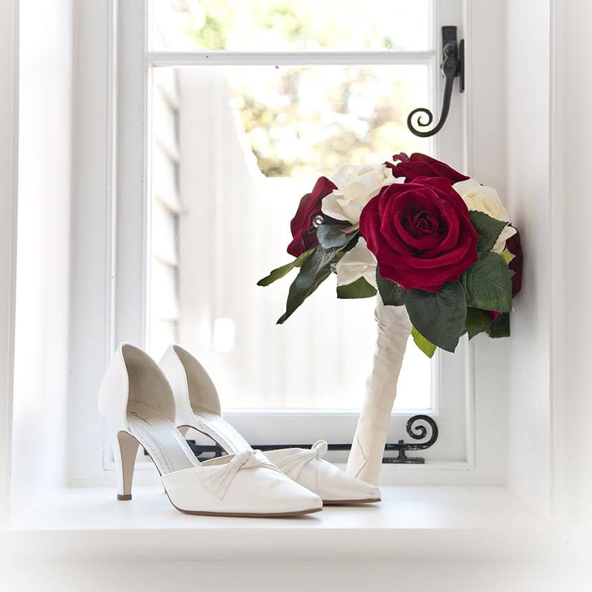 Wedding Shoes and wedding bouquet framed in a window